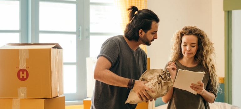 Couple checking off their list while packing for a long-distance move.