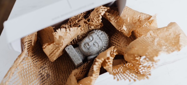Granite Buddha bust in cardboard package

