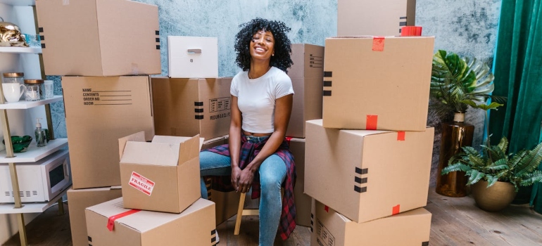 woman sitting among boxes