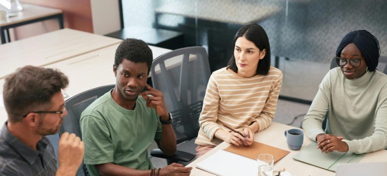 Manager discussing relocation plans with employees in an office meeting.
