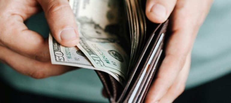 Stack of cash representing one of the common mistakes when hiring apartment movers—paying a large upfront deposit.