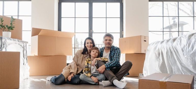 A Newly Moved Family Sitting on the Floor after moving with movers in Ontario CA