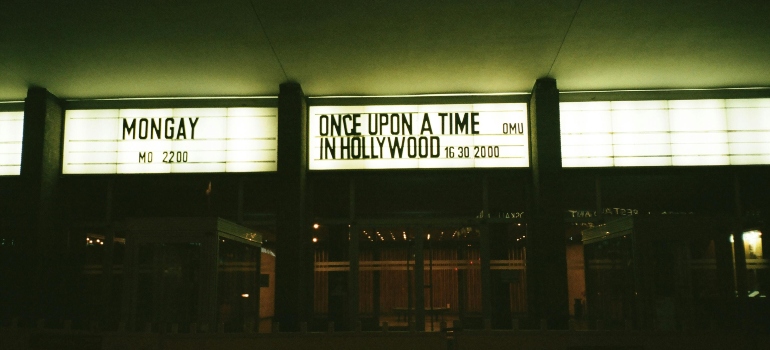 Cinema entrance at night displaying “Once Upon a Time in Hollywood” on the marquee, evoking classic Hollywood charm.