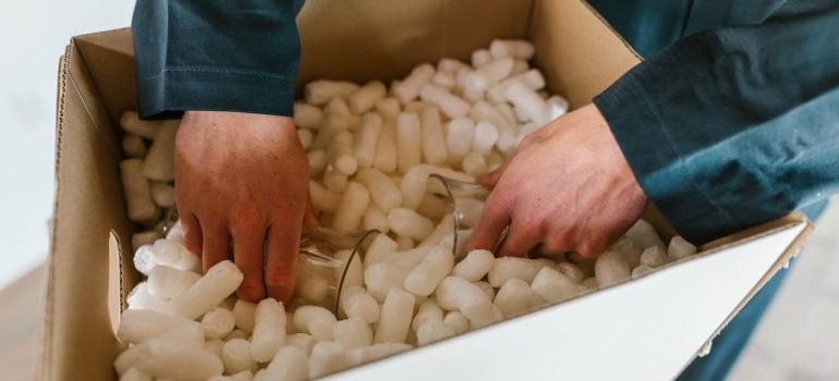 A Person Putting the Glasses in a Box Full of Polystyrene Foam