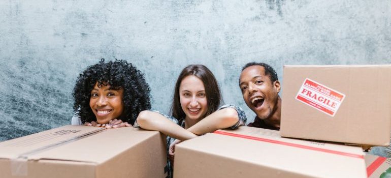 People Happy Standing Behind Package Boxes and waiting for West Covina movers