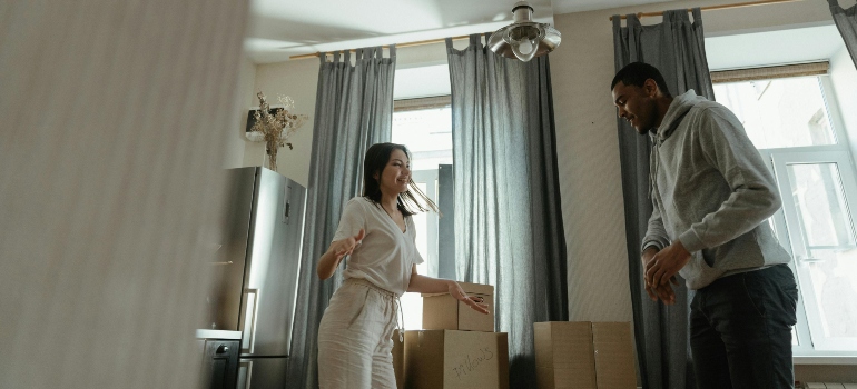 A happy couple dancing at their new apartment after the help of movers Alhambra, CA​