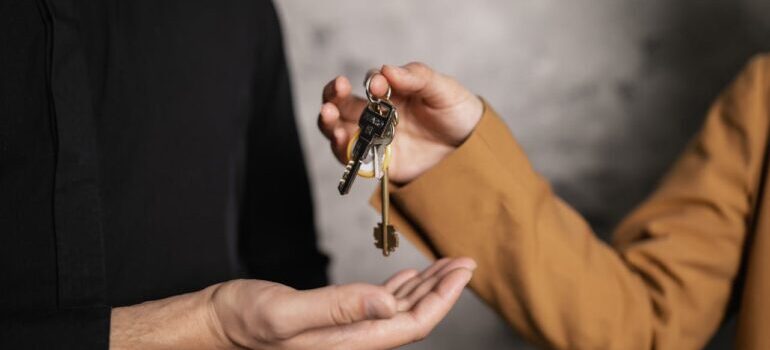A Person Giving a Bundle of Keys to another Person