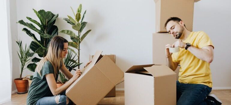 Content couple packing belongings into carton boxes while waiting for Encino movers