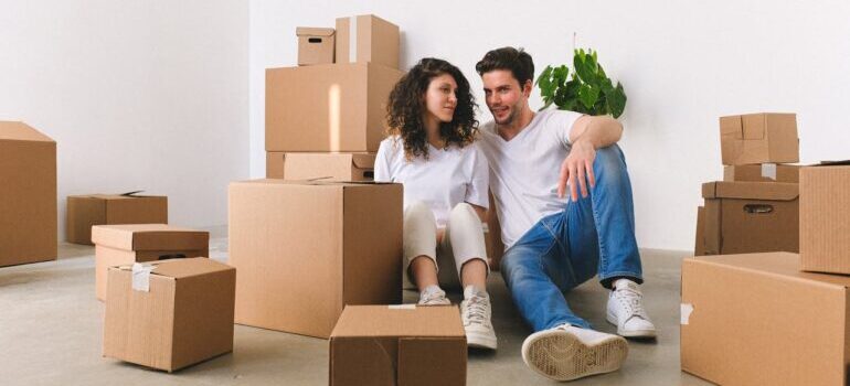Happy couple among unpacked carton boxes