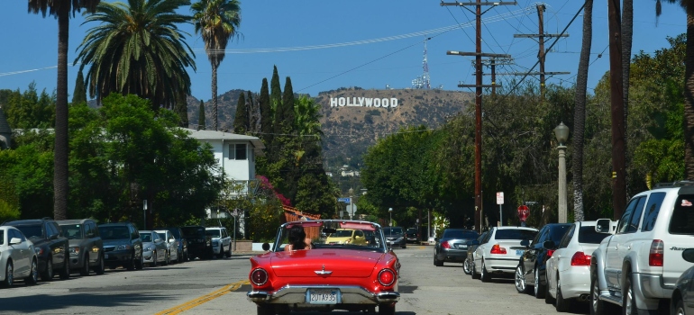 Red car on the road while exploring the best neighborhoods in Los Angeles for first-time renters.