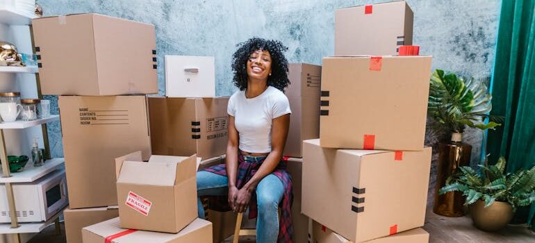 woman smiling sitting on moving boxes
