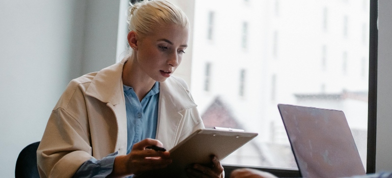 Serious businesswoman reading documents in office