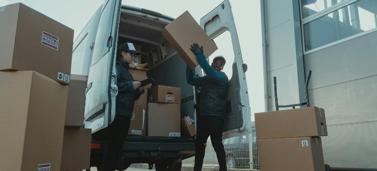 Moving man carrying boxes, showing the benefits of hiring white glove movers for fragile items.