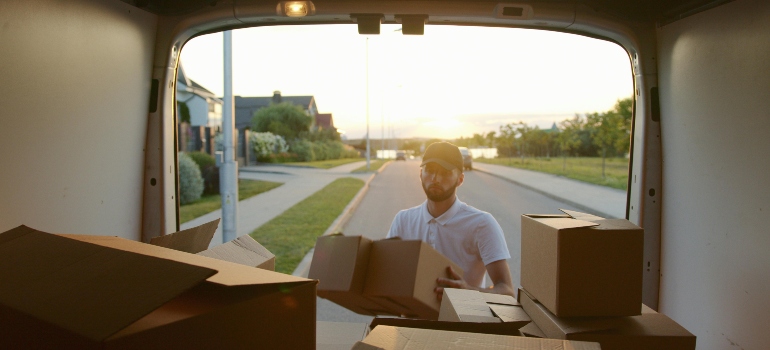 a boy packing boxes in the van