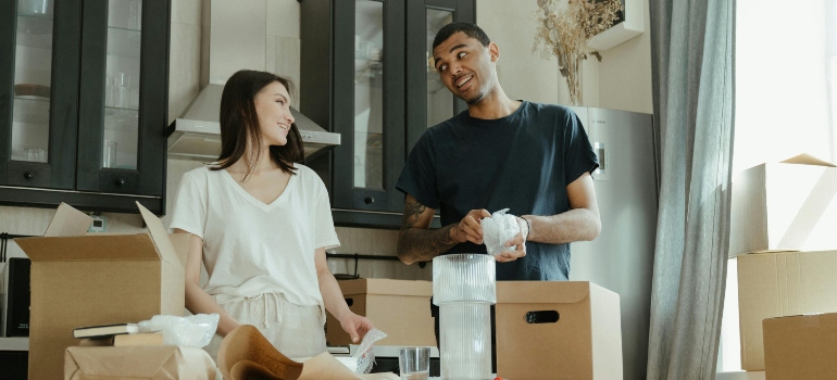 A couple is packing fragile items for their move to Calabasas.