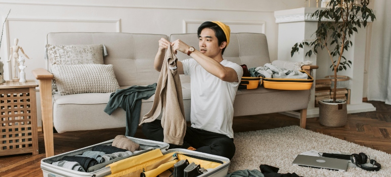 A man is packing his stuff into a suitcase, thinking about how to prepare for a smooth move to Calabasas.