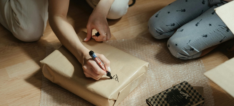 Person labeling a packed item clearly to ensure easy identification during the move