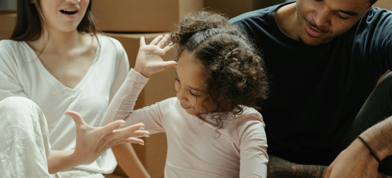 A family is sitting on the floor, finishing packing stuff.