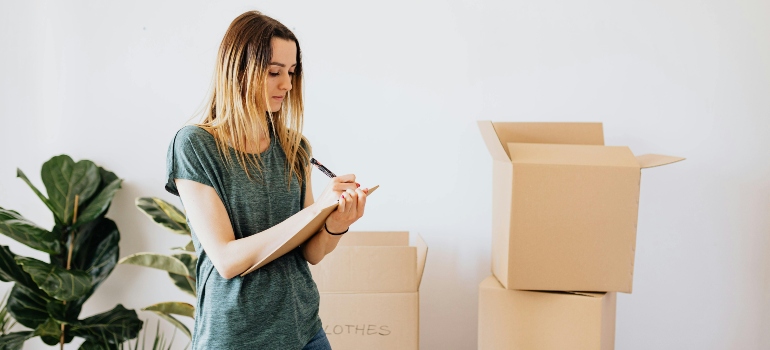Woman checking an inventory list to track belongings stored in temporary storage during a move