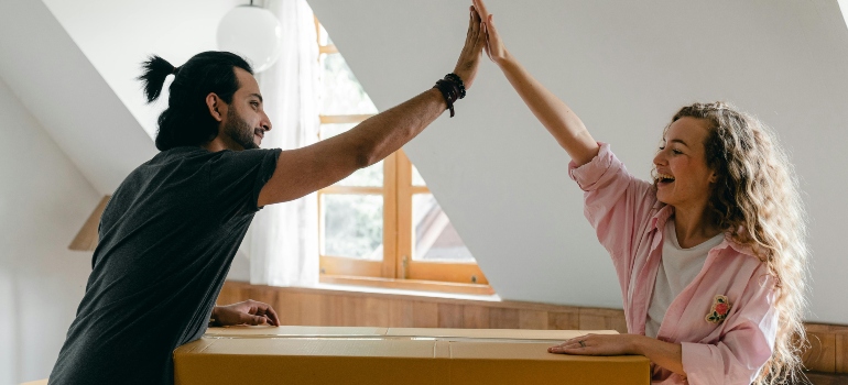 Excited couple settling into a new apartment after they move specialty items from Pacific Palisades to Beverly Hills