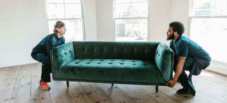 Professional movers carefully transporting sofa during a residential move in Torrance, CA.