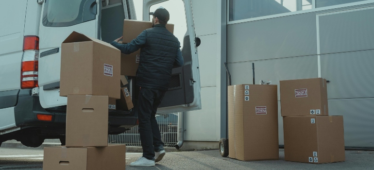 Man loading boxes into a moving truck demonstrating comprehensive moving services by reliable movers Tarzana CA