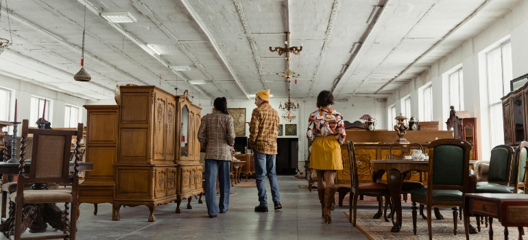 Two Women and a Man Having A Look At A Furniture Shop